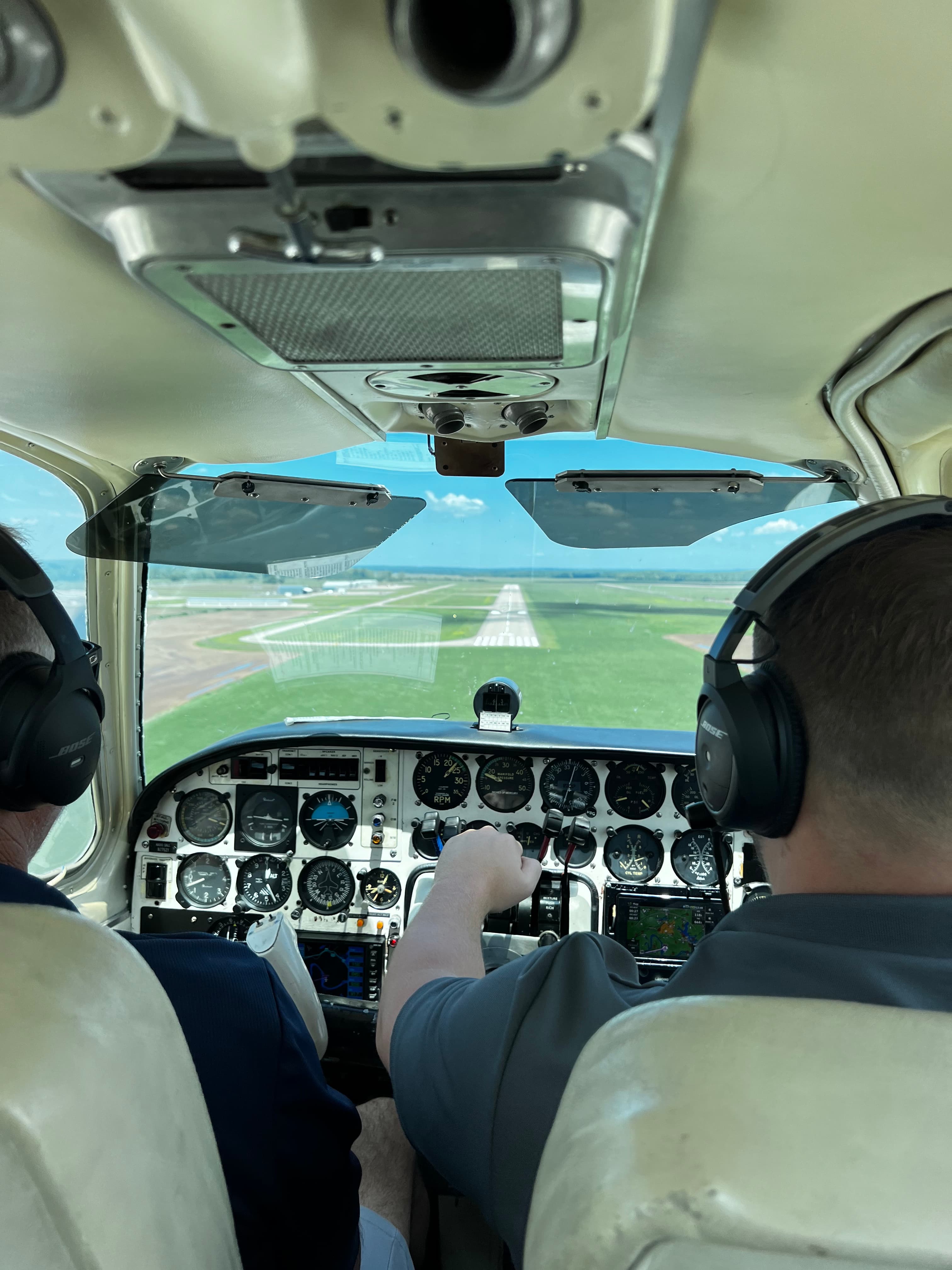 Two Superior Aviation pilots in headsets at the cockpit instrument panel in flight over the Arkansas countryside