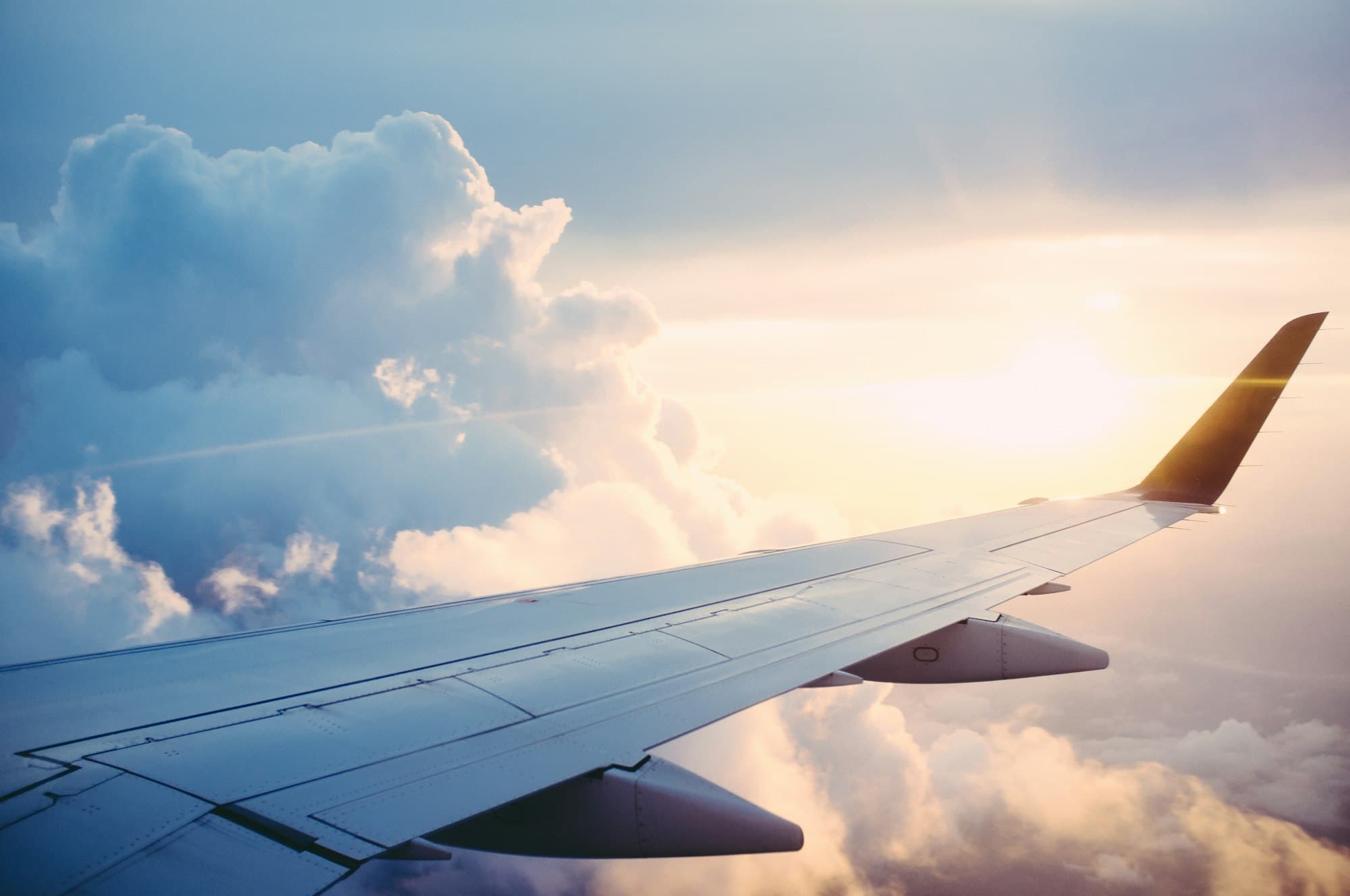 View from a small aircraft wing above clouds
