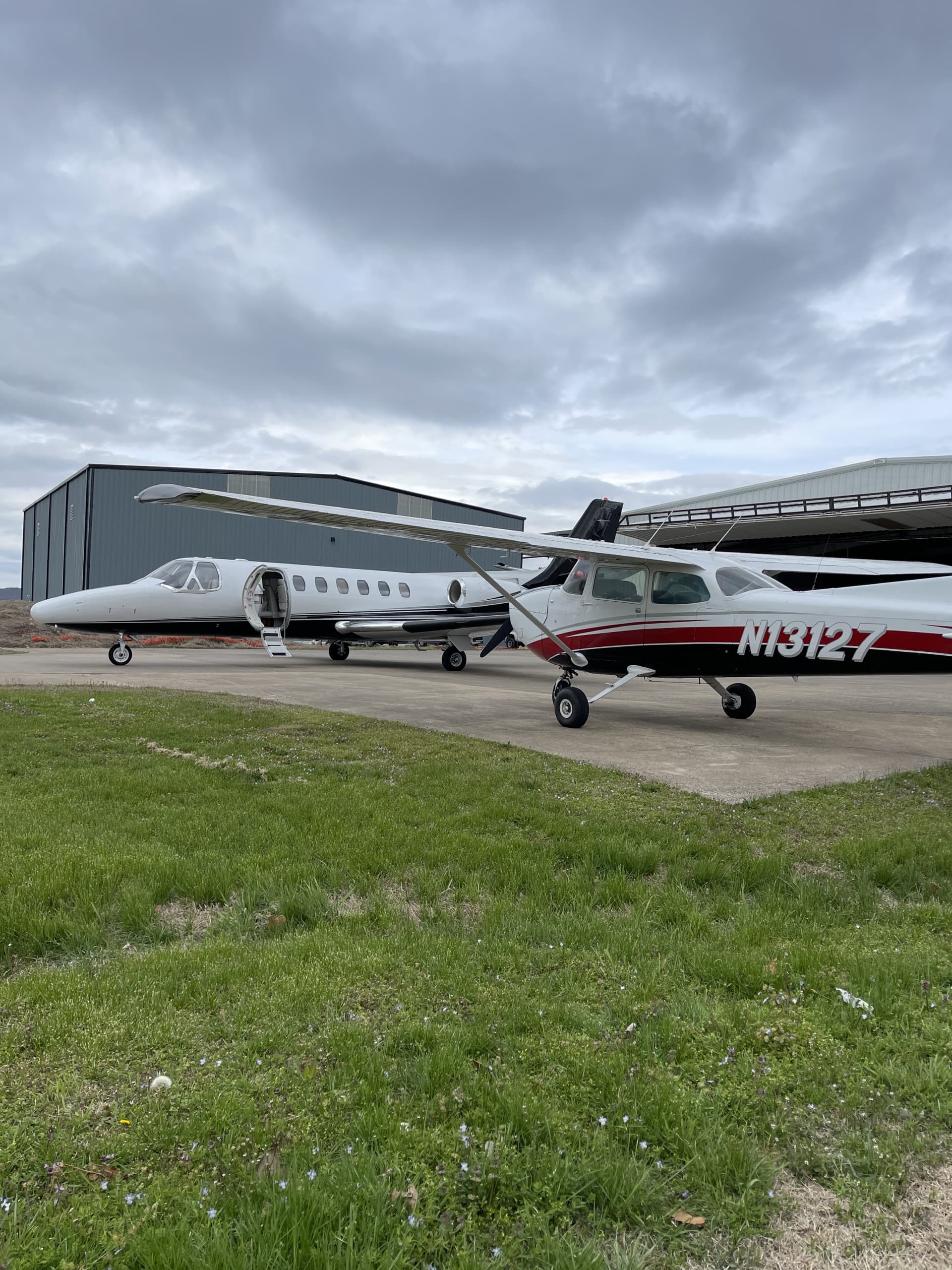 A Superior Aviation business jet and Cessna 172 (N13127) parked by the hangars